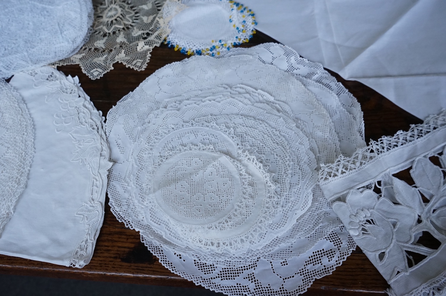 A 19th century large linen cut work collar, together with various sets of circular cut work mats, a tasselled pelmet and a collection of bobbin lace and tatting worked mats etc., Condition - mostly good